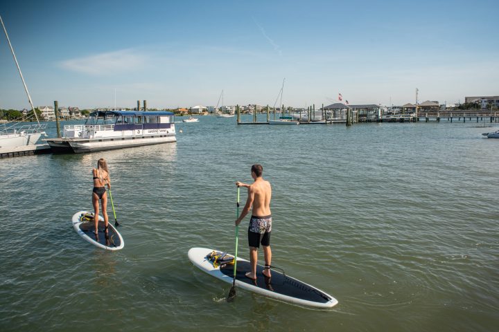 a man riding on the back of a boat in the water