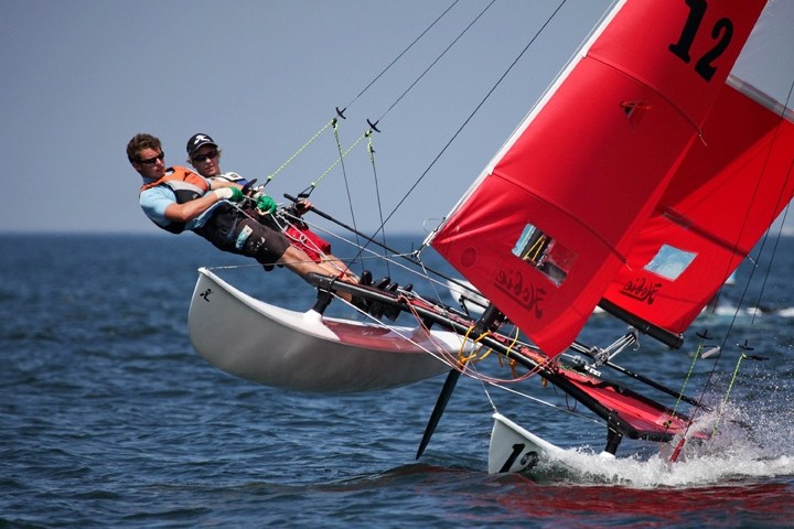 a man holding a kite in a boat on a body of water